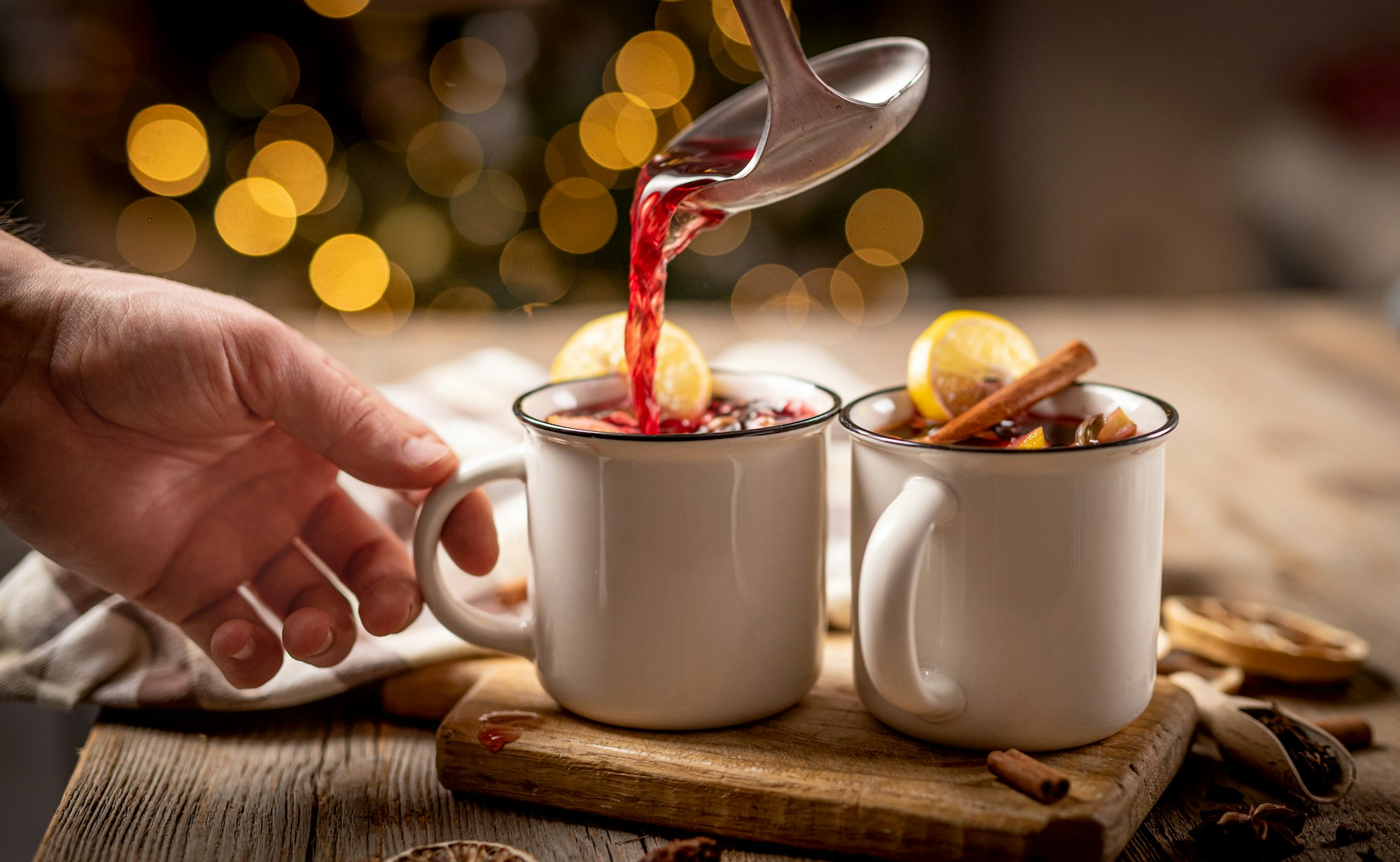 Pouring hot mulled wine into steel cups